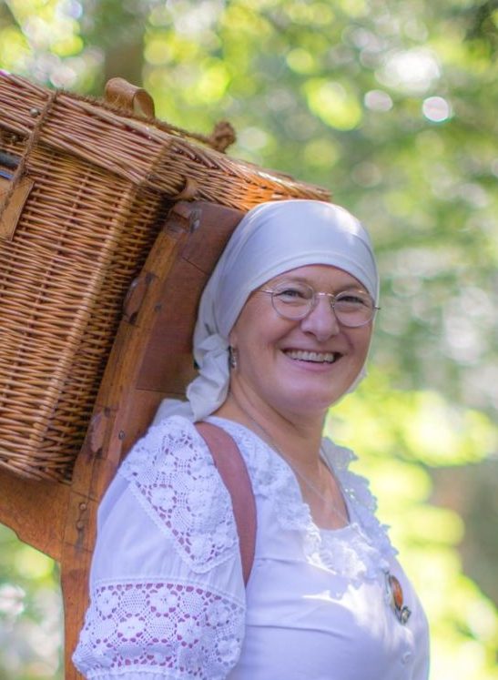 Bucklapoteca mit Reff Frau im Kostüm mit einem Weidenkorb auf einem Holzreff