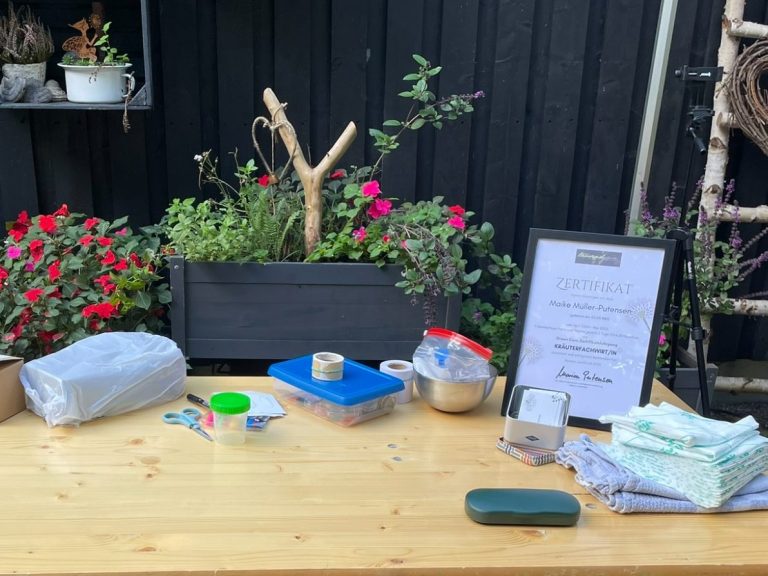 Workshop Tisch Ein Tisch mit Kurs Utensilien, Pflanzen und einem Beschilderungsschild im Hintergrund.